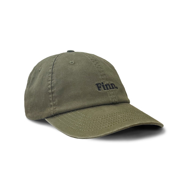 Angled view of Dusty Olive Acts of Leisure Cap Flat laid over white background