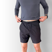 Front view of model wearing black Body Move Shorts in studio