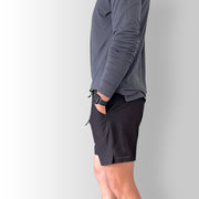 Side view of model wearing black Body Move Shorts in studio