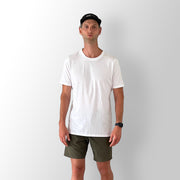 Front view of model wearing a white Out There Organic Tee in studio.