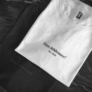 Black and white Out There Organic Logo Tees folded on benchtop