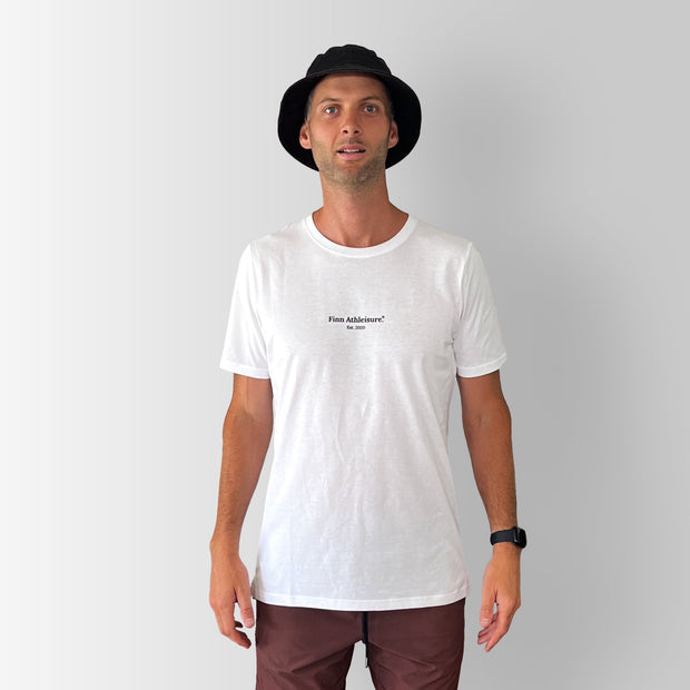 Front view of model wearing a white Out There Organic Logo Tee in studio.