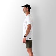 Side view of model wearing a white Out There Organic Tee in studio.