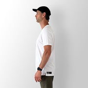 Side view of model wearing a white Out There Organic Tee in studio.
