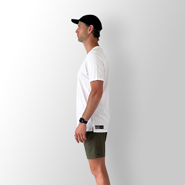 Side view of model wearing a white Out There Organic Tee in studio.