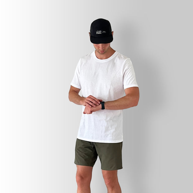 Front angled view of model wearing a white Out There Organic Tee in studio.