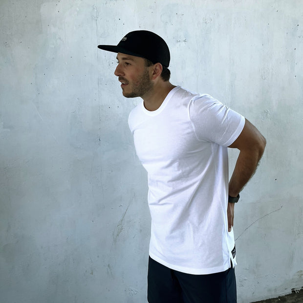 Model wearing White Out There Organic Tee in urban setting.